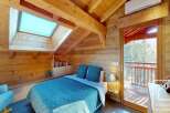 Discover the charm of this cozy bedroom, featuring a unique wooden ceiling and walls that exude warmth and character.