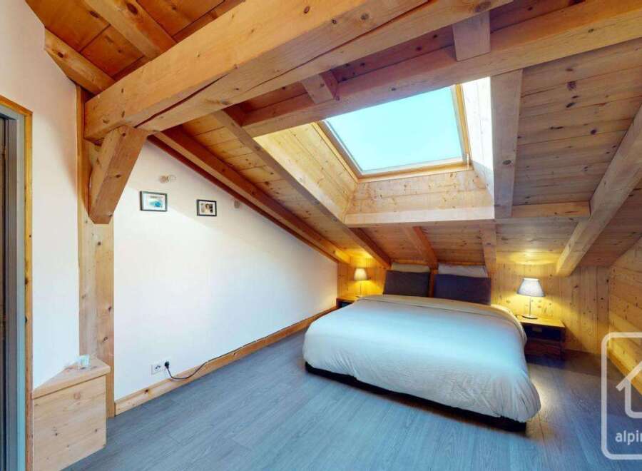 Discover the charm of this stunning property, featuring a cozy bedroom with a unique wooden ceiling and a skylight that floods the space with natural light.