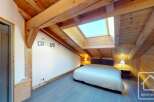Discover the charm of this stunning property, featuring a cozy bedroom with a unique wooden ceiling and a skylight that floods the space with natural light.