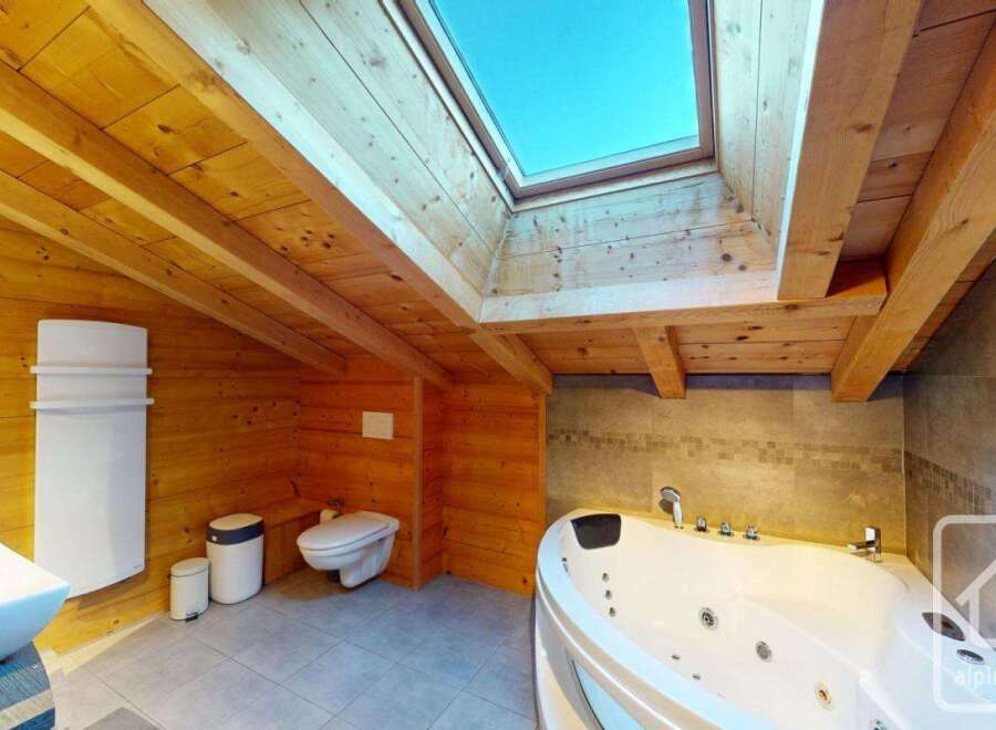 Experience luxury in this stunning bathroom featuring a jacuzzi and a skylight.