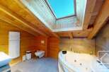 Experience luxury in this stunning bathroom featuring a jacuzzi and a skylight.