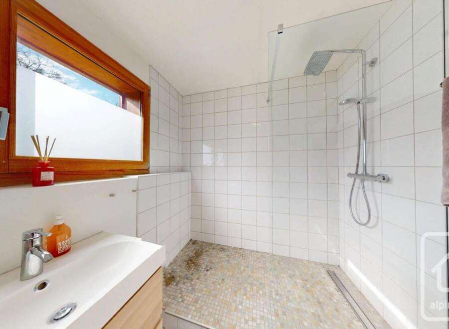 This modern bathroom features a sleek design with a walk-in shower and a stylish vanity.
