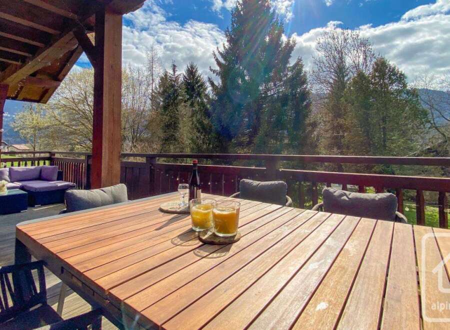 Enjoy breathtaking views from this stunning property! This outdoor space features a beautiful wooden table, perfect for dining al fresco.
