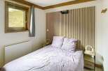 Discover the charm of this cozy bedroom, featuring a stylish wooden headboard and a comfortable bed.