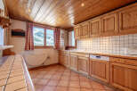 This charming kitchen boasts a warm, inviting atmosphere with its wooden cabinets and ceiling.