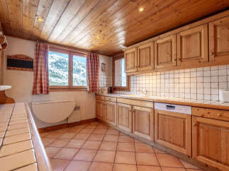 This charming kitchen boasts a warm, inviting atmosphere with its wooden cabinets and ceiling.