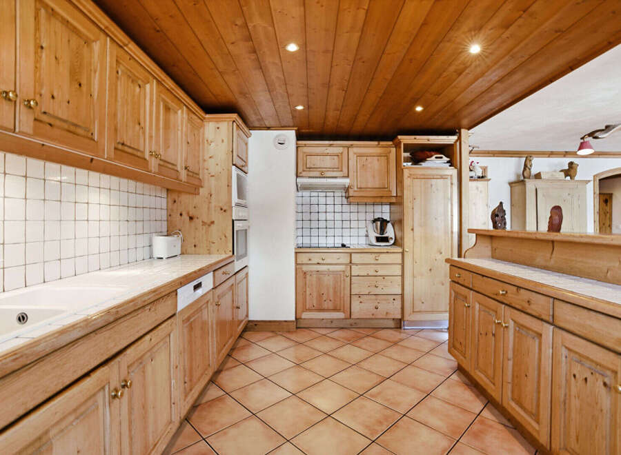 This stunning kitchen boasts a warm and inviting atmosphere with its natural wood cabinetry and tiled countertops.