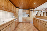 This stunning kitchen boasts a warm and inviting atmosphere with its natural wood cabinetry and tiled countertops.