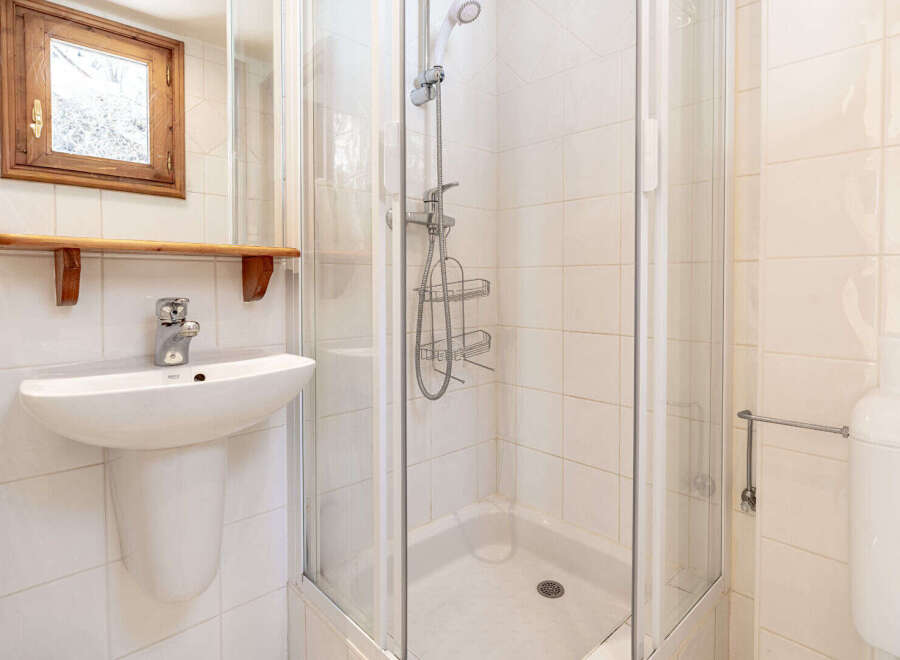 Step into this charming bathroom, featuring a modern shower and a sleek sink.