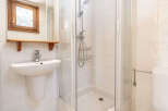 Step into this charming bathroom, featuring a modern shower and a sleek sink.