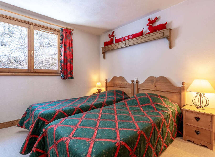 This cozy bedroom features two twin beds with a charming quilt design, perfect for a comfortable stay.