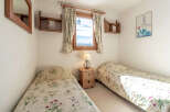 This charming bedroom features two twin beds with floral bedding, perfect for a cozy retreat.