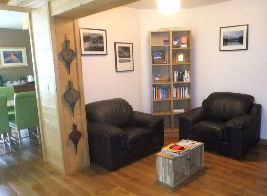 This cozy living space features two comfortable black leather armchairs, perfect for relaxing.