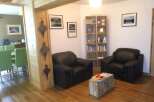 This cozy living space features two comfortable black leather armchairs, perfect for relaxing.