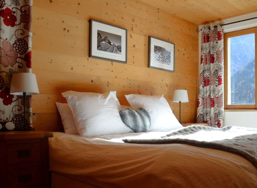 Experience the warmth of this cozy bedroom, featuring stunning wood paneling that adds a touch of rustic elegance.