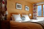 Experience the warmth of this cozy bedroom, featuring stunning wood paneling that adds a touch of rustic elegance.