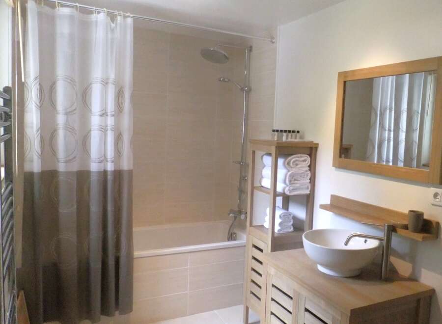This modern bathroom features a sleek design with a shower and a bathtub.