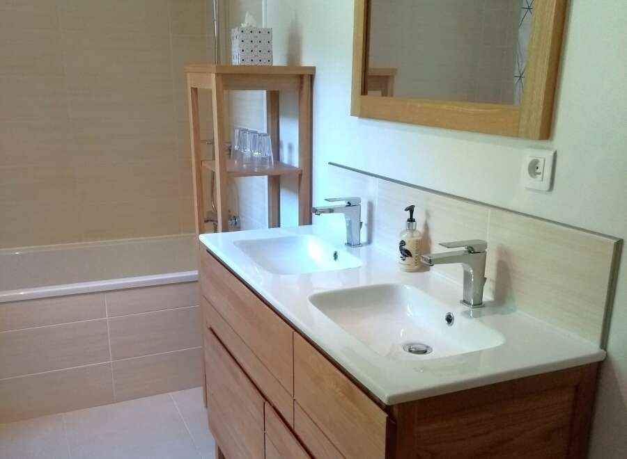 This modern bathroom features a double vanity with sleek chrome faucets and a bright, clean design.
