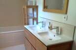 This modern bathroom features a double vanity with sleek chrome faucets and a bright, clean design.