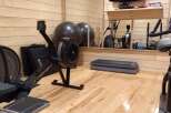 This home gym is perfect for staying in shape, featuring a Concept 2 rower, exercise balls, and a step platform.