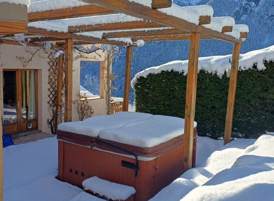Enjoy the winter wonderland from the comfort of your own home! This property features a cozy hot tub, perfect for relaxing after a day on the slopes.
