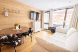 This cozy apartment features a warm, inviting living space with wood paneling and a modern design.