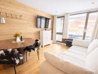 This cozy apartment features a warm, inviting living space with wood paneling and a modern design.