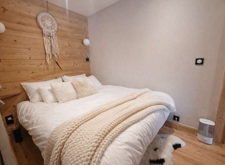 This cozy bedroom features a rustic wooden accent wall, creating a warm and inviting atmosphere.