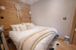 This cozy bedroom features a rustic wooden accent wall, creating a warm and inviting atmosphere.