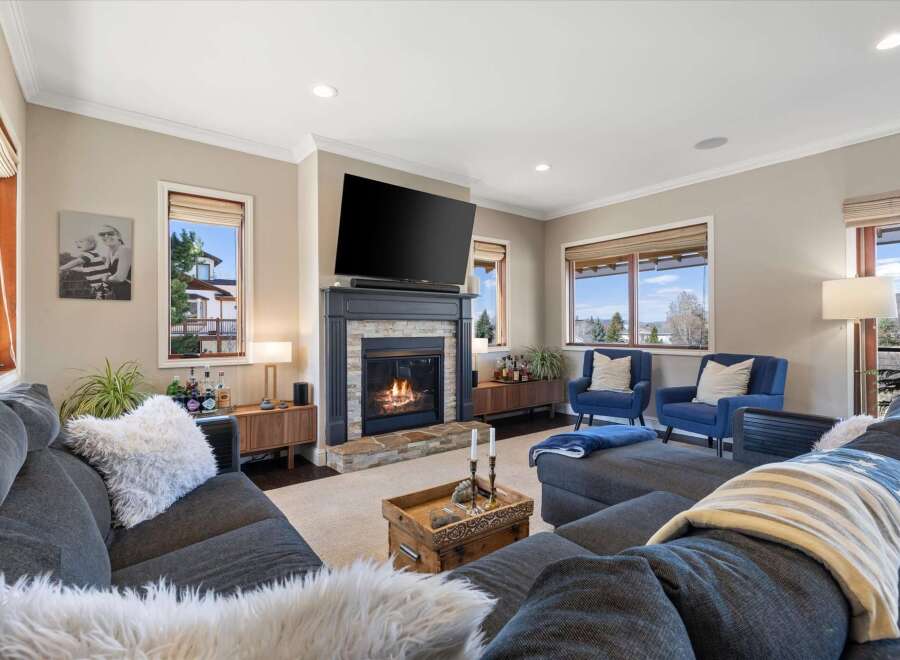 Step into luxury with this stunning living room, featuring a cozy fireplace and a large flat-screen TV, perfect for entertaining.