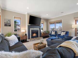 Step into luxury with this stunning living room, featuring a cozy fireplace and a large flat-screen TV, perfect for entertaining.