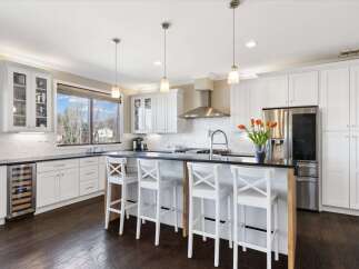 This stunning kitchen boasts a modern design with sleek white cabinetry and a spacious island, perfect for both cooking and entertaining.