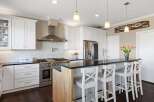 This stunning kitchen boasts a modern design with sleek white cabinetry and a contrasting black countertop.