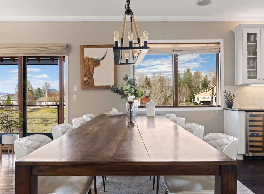 This stunning dining room boasts a rustic wooden table, perfect for hosting gatherings.