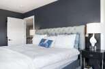 This stunning bedroom boasts a luxurious tufted headboard and plush bedding, creating a serene and inviting atmosphere.