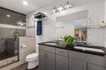 Step into modern luxury with this stunning bathroom! Featuring sleek gray cabinetry, a black countertop, and a double sink, this space is both stylish and functional.