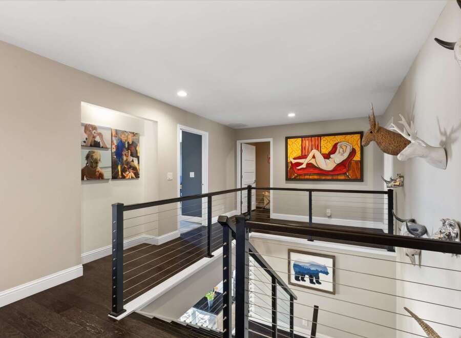 This stunning property boasts a modern interior with dark wood flooring and sleek metal railings, creating a sophisticated ambiance.