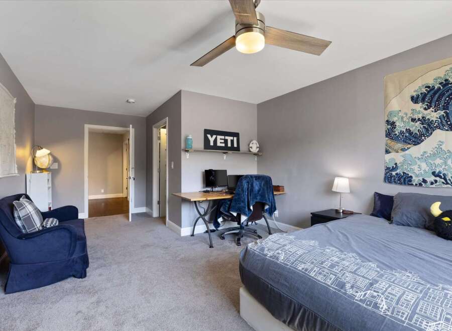 Step into this inviting bedroom, featuring a cozy armchair and a stylish desk setup perfect for work or study.