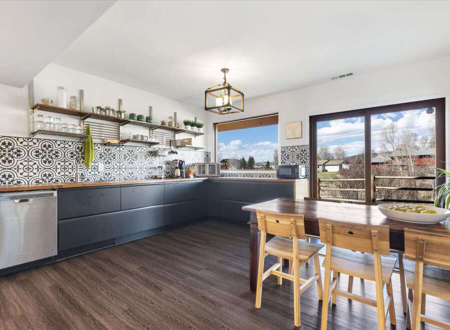 This stunning kitchen boasts a modern design with sleek, dark cabinetry and beautiful patterned backsplash.