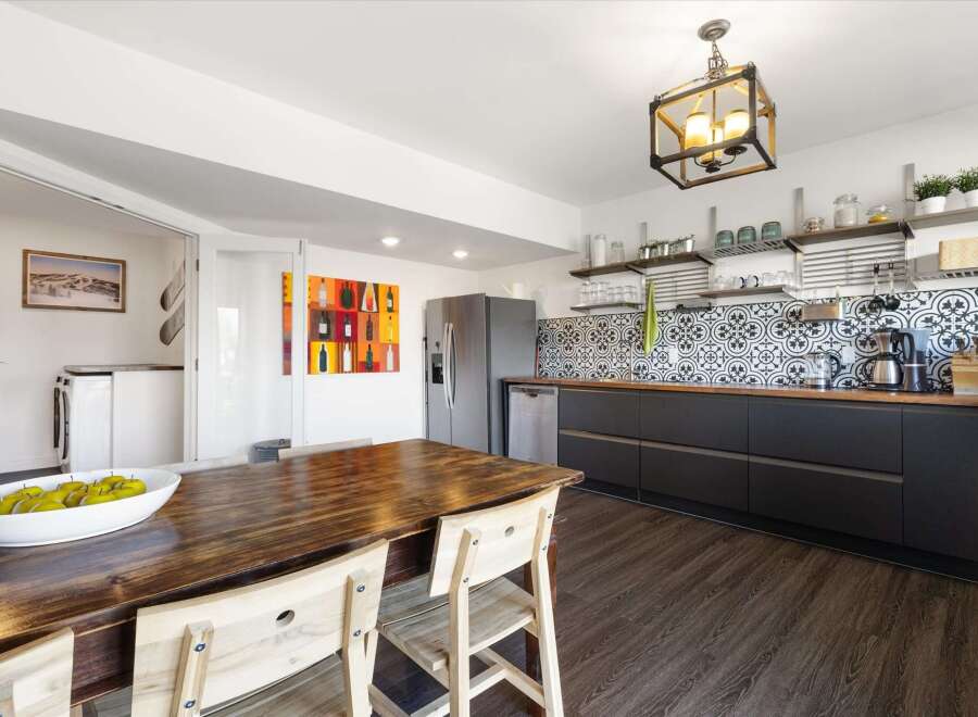 This stunning kitchen boasts a modern design with sleek black cabinetry and a beautiful wooden countertop.