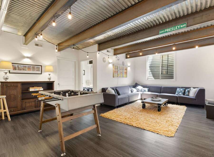 Discover this stylish living space featuring a unique corrugated metal ceiling and exposed beams, creating an industrial-chic vibe.