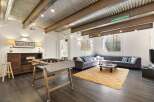 Discover this stylish living space featuring a unique corrugated metal ceiling and exposed beams, creating an industrial-chic vibe.
