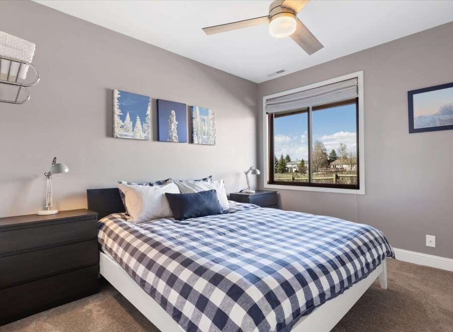 This inviting bedroom features a cozy bed with a stylish blue and white checkered comforter.