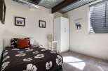 This cozy bedroom features a unique corrugated metal ceiling and exposed beams, adding a touch of industrial charm.