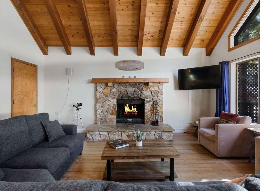 Cozy up in this charming living room, featuring a stunning stone fireplace and a warm, inviting atmosphere.