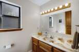 This bathroom features a stylish vanity with a unique countertop design and wooden cabinets.