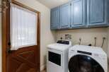 Step into the convenience of this well-appointed laundry room, featuring modern appliances and ample storage.