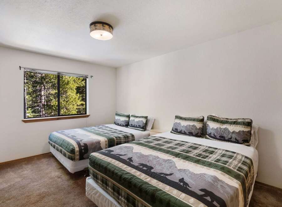 This cozy bedroom features two twin beds with nature-themed bedding, perfect for a comfortable stay.