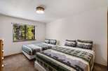 This cozy bedroom features two twin beds with nature-themed bedding, perfect for a comfortable stay.