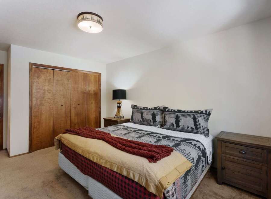 This cozy bedroom features a comfortable bed with a unique patterned comforter and decorative pillows.